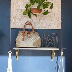 Consuela quilted champagne colored hand bag.